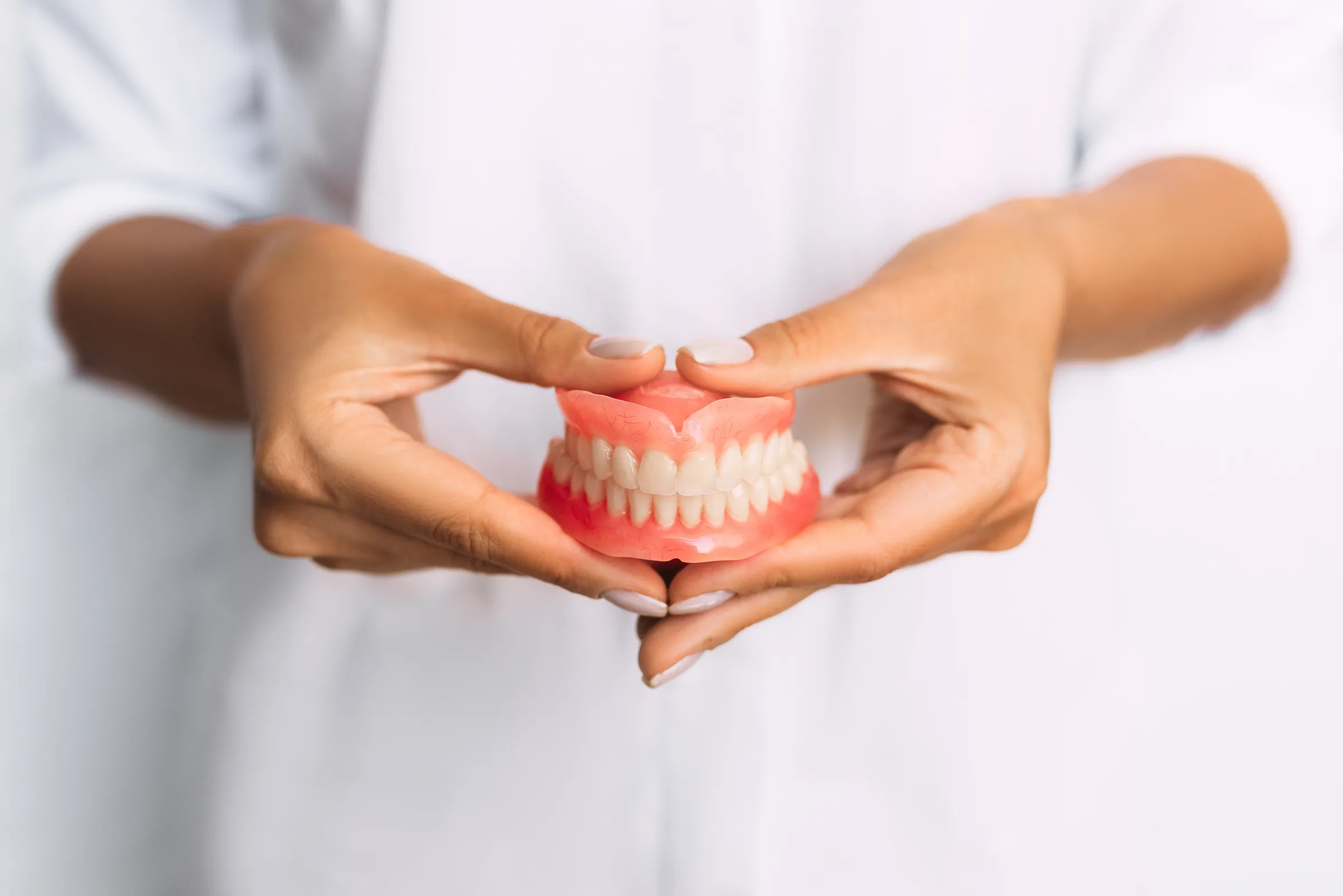 Hands holding a full denture