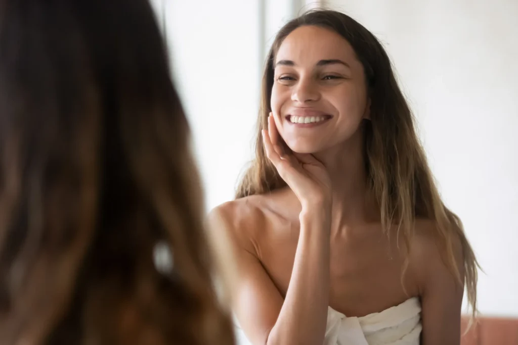 Smiling woman looking at her reflection in a mirror