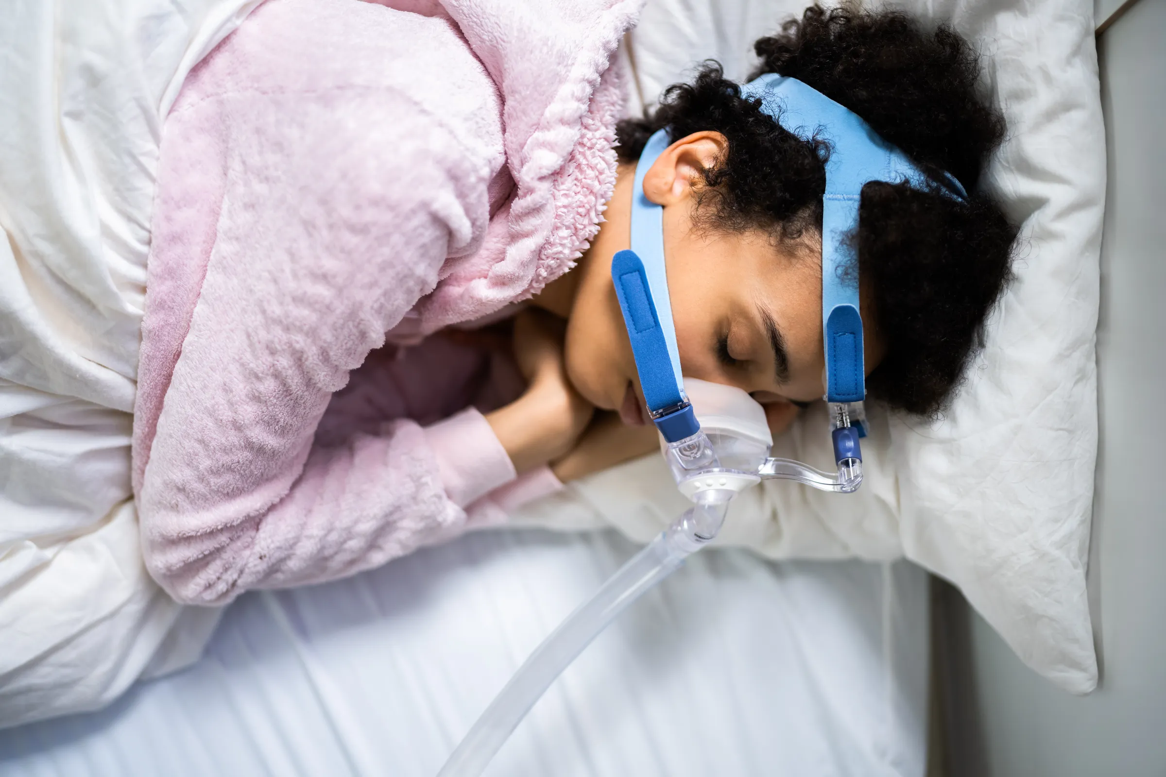 Woman asleep wearing a CPAP mask