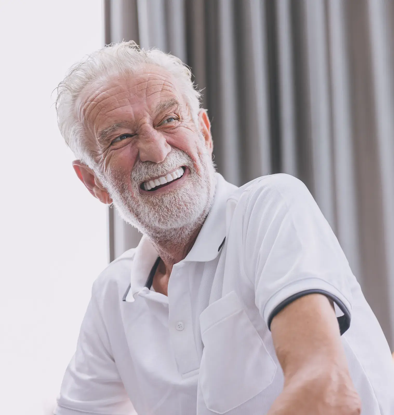 Smiling older man seated in a living room