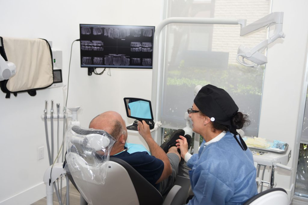 Assistant showing a patient images on a tablet in the treatment chair