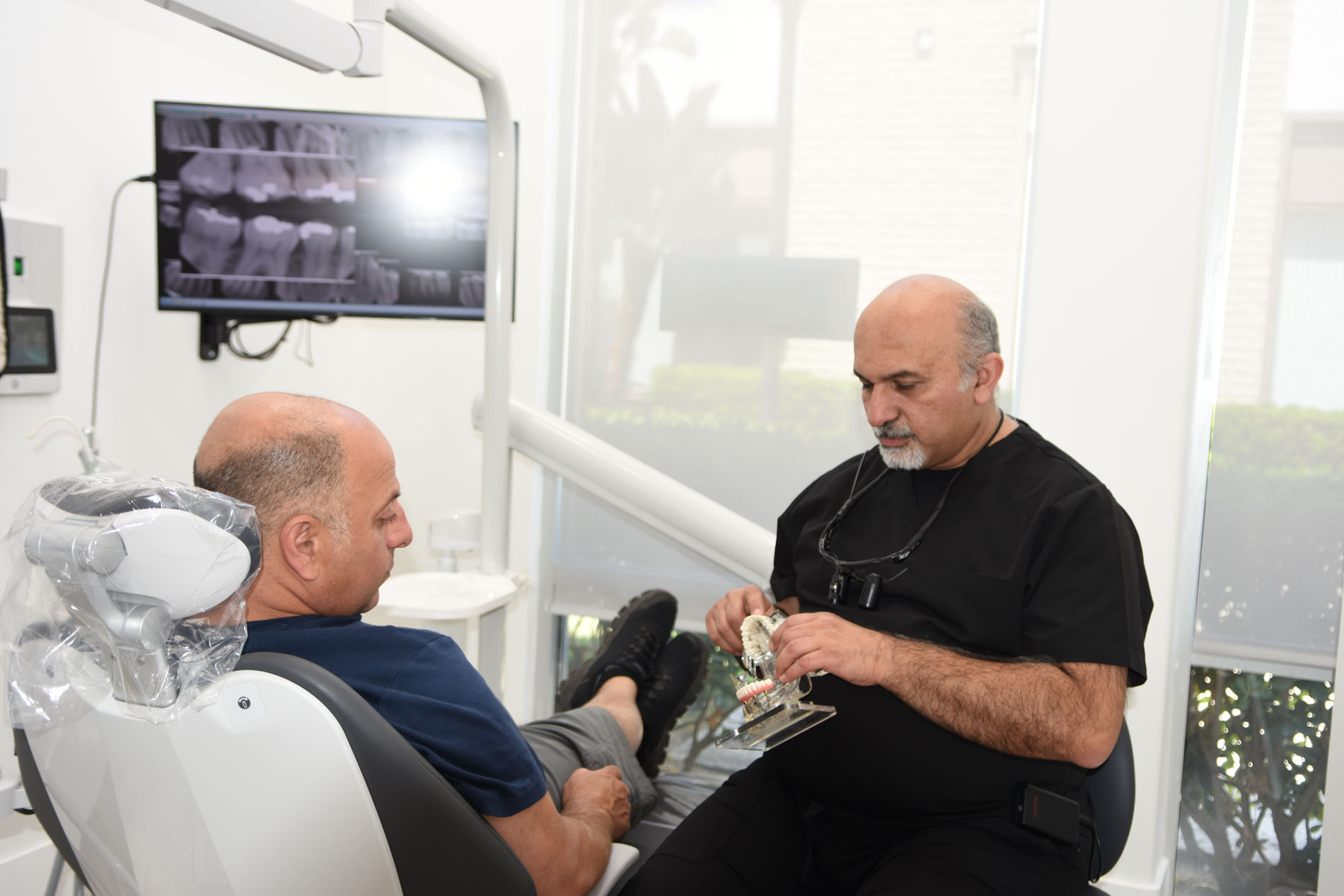 Dr. Haroonian explaining a treatment model to a patient