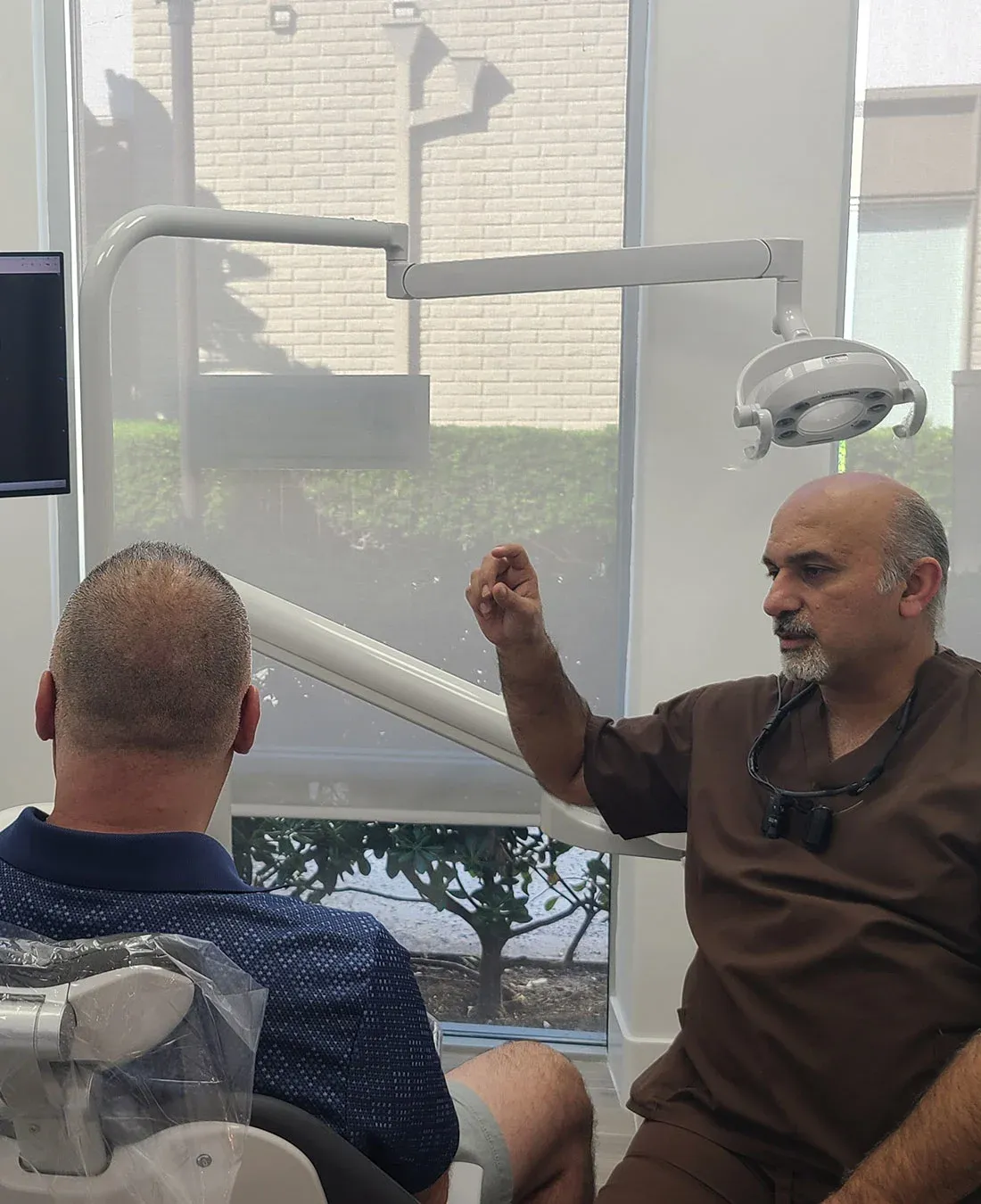 Dr. Haroonian explaining treatment to a patient in the chair