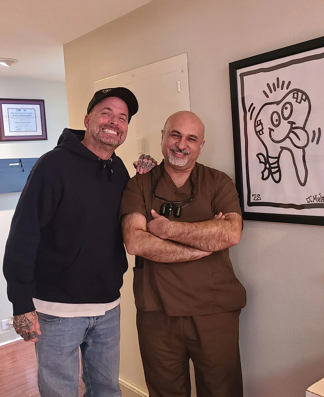 Dr. Haroonian with a smiling patient in the office hallway