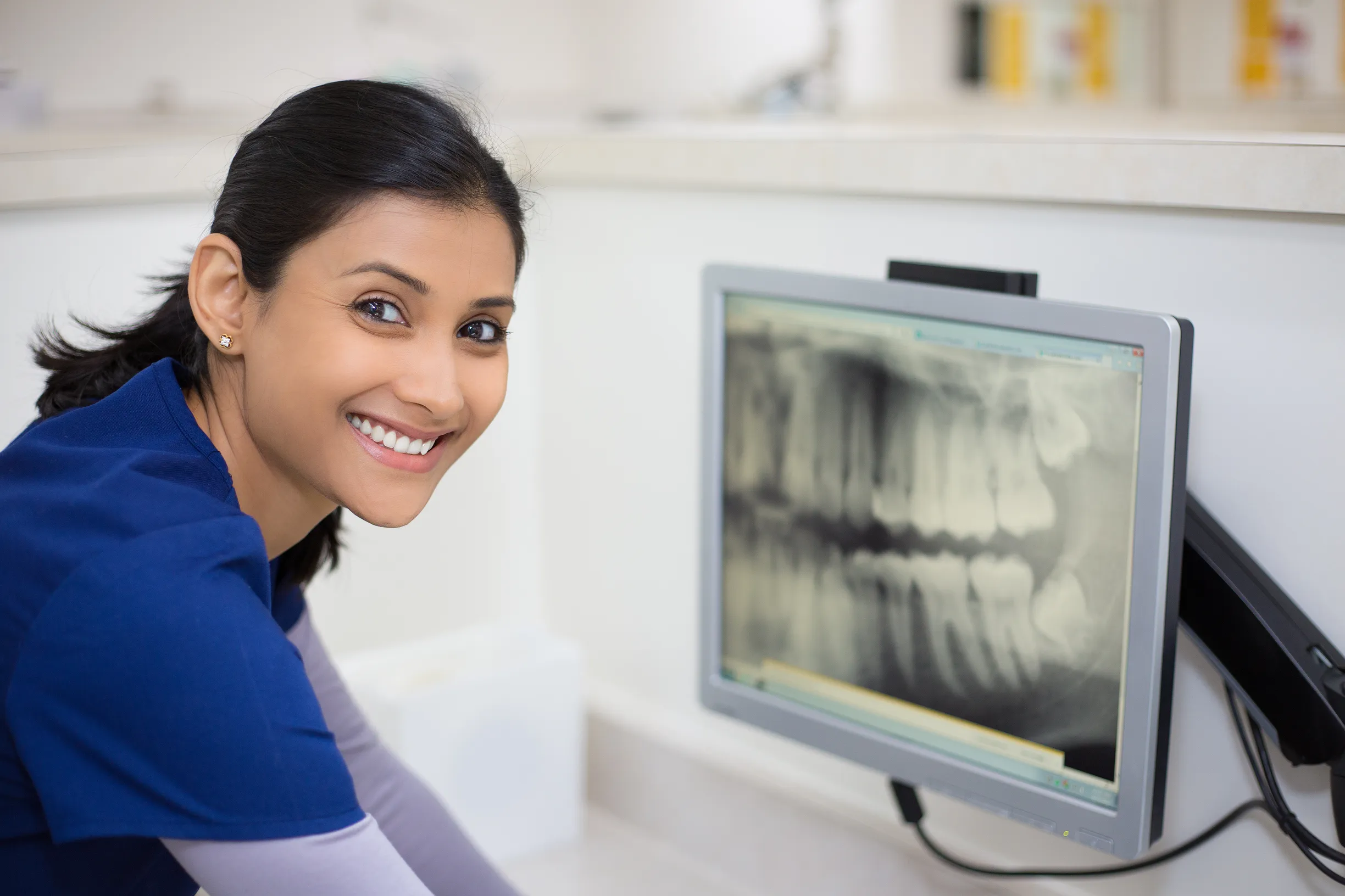 Dental assistant reviewing digital X-rays